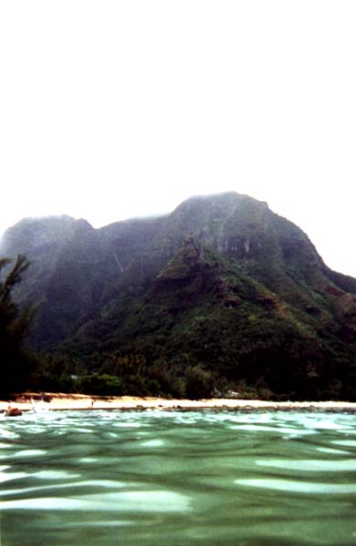 view
of steep green mountains
overlooking water.  The photo was taken in the water so there is no land
between foreground and mountain.