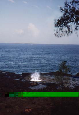 Photo of vertical shower sea spray escaping out of underground sea cave.