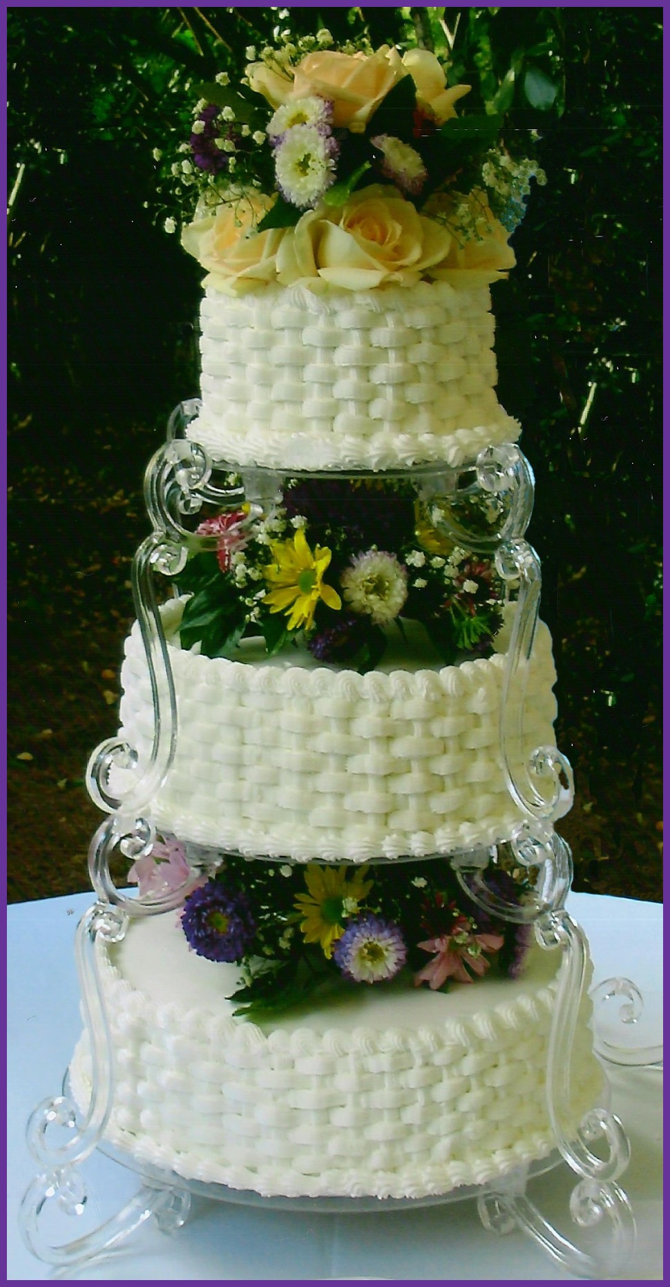 Wedding Cake with multi-colored flowers and stairway to heaven stands.