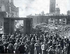 The debris of the Cornmarket with workers returning the next morning to begin work.  The dock buildings are in the background.