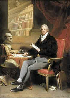 William Roscoe seated next to a bust of Charles James Fox, his political hero and in front are several copies of Roscoe's biography of Pope Leo X